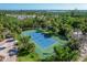 Aerial shot of well-maintained community tennis court surrounded by lush trees, perfect for active residents at 7470 Palm Island Dr # 2813, Placida, FL 33946