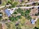 Top-down view showcasing a property with a winding driveway and lush tree cover at 760 S Oxford Dr, Englewood, FL 34223