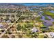 Overhead view of a neighborhood featuring homes interspersed with verdant trees and canals at 760 S Oxford Dr, Englewood, FL 34223