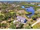 Aerial view of modern home nestled on a canal with dock, surrounded by lush greenery at 760 S Oxford Dr, Englewood, FL 34223