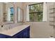 This modern bathroom features double sinks and views of the lush tropical landscape at 760 S Oxford Dr, Englewood, FL 34223