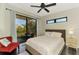 Bedroom showcasing balcony access with outdoor seating, ceiling fan, and natural light at 760 S Oxford Dr, Englewood, FL 34223