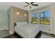 Bright bedroom features a decorative accent wall, ceiling fan, and windows showcasing the beautiful outdoor scenery at 760 S Oxford Dr, Englewood, FL 34223