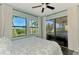 A bedroom with scenic views from its large windows and a sliding door to the outdoor patio at 760 S Oxford Dr, Englewood, FL 34223