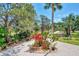 Beautiful driveway lined with tropical trees and flowering plants leading to the home at 760 S Oxford Dr, Englewood, FL 34223