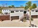 Contemporary home with a private deck, dual garages, and stylish entry staircase at 760 S Oxford Dr, Englewood, FL 34223
