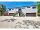 Modern two-story home featuring a light gray exterior, a gravel driveway, and double garages at 760 S Oxford Dr, Englewood, FL 34223