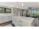 Bright open kitchen featuring a large island, white cabinets and access to the outdoor living space at 760 S Oxford Dr, Englewood, FL 34223