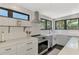 Close up of bright kitchen with white subway tiles, range hood, and stainless steel oven at 760 S Oxford Dr, Englewood, FL 34223