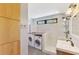 Bright laundry room with modern washer and dryer, ample storage, and a walk-in shower at 760 S Oxford Dr, Englewood, FL 34223
