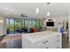 Bright, open living space featuring sliding glass doors, ceiling fans, and a modern white kitchen island at 760 S Oxford Dr, Englewood, FL 34223