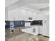 Kitchen featuring white cabinetry, stainless steel appliances, granite countertops, dark backsplash, and wood flooring at 821 Montrose Dr # 201, Venice, FL 34293