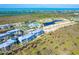 An aerial view of a luxury condo community, highlighting lush landscaping, a pond, and amenities at 8413 Placida Rd # 205, Placida, FL 33946