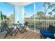Spacious screened balcony featuring a cozy seating area and views of lush trees and blue skies at 8413 Placida Rd # 205, Placida, FL 33946