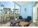 Relaxing screened balcony with stylish seating, a charming lizard wall hanging, and peaceful wooded views at 8413 Placida Rd # 205, Placida, FL 33946