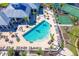 Aerial view of a community pool and clubhouse surrounded by manicured landscaping and various amenities at 8413 Placida Rd # 205, Placida, FL 33946