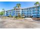 Modern condo building featuring multiple stories, balconies, and tropical landscaping on a sunny day at 8413 Placida Rd # 205, Placida, FL 33946