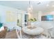 Dining area with a round table, white chairs, and a view of the kitchen and living space at 8413 Placida Rd # 205, Placida, FL 33946