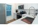 Modern kitchen with stainless steel appliances, white cabinets, and bright lighting from the window at 8413 Placida Rd # 205, Placida, FL 33946