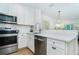 Bright kitchen with white countertops, stainless steel appliances, and a view into the living space at 8413 Placida Rd # 205, Placida, FL 33946