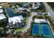 Aerial view of community with amenities including tennis courts, pool, and clubhouse surrounded by beautiful landscaping at 8500 Amberjack Cir # 102, Englewood, FL 34224
