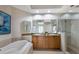 Modern bathroom featuring double vanity sinks, a glass shower, and a soaking tub at 8500 Amberjack Cir # 102, Englewood, FL 34224