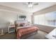 Bright bedroom featuring a ceiling fan, large window with blinds, and neutral decor at 8500 Amberjack Cir # 102, Englewood, FL 34224