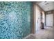 Hallway with blue tile wall, white tile flooring, table, artwork and doors on either side at 8500 Amberjack Cir # 102, Englewood, FL 34224