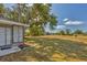 Large backyard features mature trees and lush grass, providing a serene outdoor space at 9149 Castlehill Ave, Englewood, FL 34224