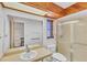 Bathroom featuring a wooden ceiling, glass shower and mirrored cabinets at 9149 Castlehill Ave, Englewood, FL 34224