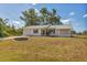 Charming single-story home with a well-manicured lawn and mature trees providing shade at 9149 Castlehill Ave, Englewood, FL 34224