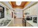 Open kitchen showcasing tile flooring, white appliances, and wood cabinets that complement the living space at 9149 Castlehill Ave, Englewood, FL 34224