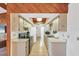 Galley kitchen featuring tile floors, bright cabinets, and stainless steel appliances with skylight at 9149 Castlehill Ave, Englewood, FL 34224
