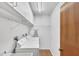 Bright laundry room featuring a washer, dryer, and overhead storage shelves at 9149 Castlehill Ave, Englewood, FL 34224
