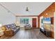 Bright living room with wood accent wall, ceiling fan, and laminate floors, open to other living spaces at 9149 Castlehill Ave, Englewood, FL 34224