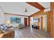 Cozy living room featuring wood-paneled walls, laminate flooring, and ample natural light at 9149 Castlehill Ave, Englewood, FL 34224