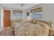 Cozy main bedroom with a floral bedspread, a ceiling fan, and bedside lamps at 9149 Castlehill Ave, Englewood, FL 34224