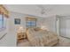 Cozy main bedroom with a floral bedspread, a ceiling fan, and bedside lamps at 9149 Castlehill Ave, Englewood, FL 34224