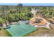 Aerial view showcases a basketball court and playground nestled among lush greenery and mature trees at 9574 Arsipe Cir, Port Charlotte, FL 33981