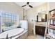 Luxurious bathroom with white marble tile, soaking tub, and glass block window, offering a bright space at 9574 Arsipe Cir, Port Charlotte, FL 33981