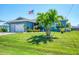 Charming home with a well-manicured lawn and a mature palm tree in the front yard at 9574 Arsipe Cir, Port Charlotte, FL 33981