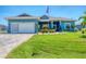 Charming single-story home featuring a well-manicured lawn and a lovely paver driveway at 9574 Arsipe Cir, Port Charlotte, FL 33981