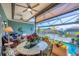 Outdoor oasis: covered lanai with waterfront views, stylish furnishings, and a refreshing pool for relaxation at 9574 Arsipe Cir, Port Charlotte, FL 33981
