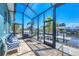 Screened patio featuring brick pavers and direct access to the canal and dock area at 9574 Arsipe Cir, Port Charlotte, FL 33981