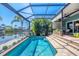 Screened-in pool with a waterfront view, surrounded by tropical plants and ample patio space at 9574 Arsipe Cir, Port Charlotte, FL 33981