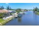 Waterfront home with boat lift, dock, screened pool, and tropical landscaping at 9574 Arsipe Cir, Port Charlotte, FL 33981