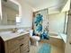 Bathroom with a sink with wood cabinets, toilet and tub with a turtle shower curtain at 9580 Almirate Ct, Placida, FL 33946
