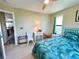 A cozy bedroom featuring a blue tropical themed bed set and a white wicker accent chair at 9580 Almirate Ct, Placida, FL 33946