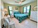 Bedroom with tiled floors, two windows with green curtains, and a decorative bedspread at 9580 Almirate Ct, Placida, FL 33946