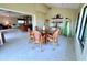 Bright dining room featuring large windows and seating for six around a glass table, open to the kitchen at 9580 Almirate Ct, Placida, FL 33946